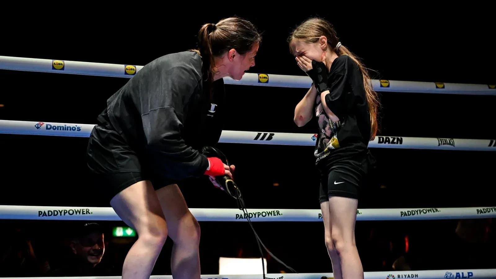 Boxeadora hablando con niña en el ring