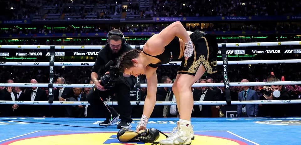 Boxeadora recogiendo guantes en el ring