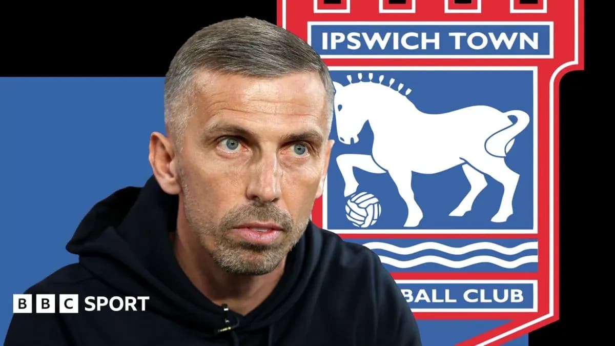 Entrenador hablando con logo de Ipswich Town detrás