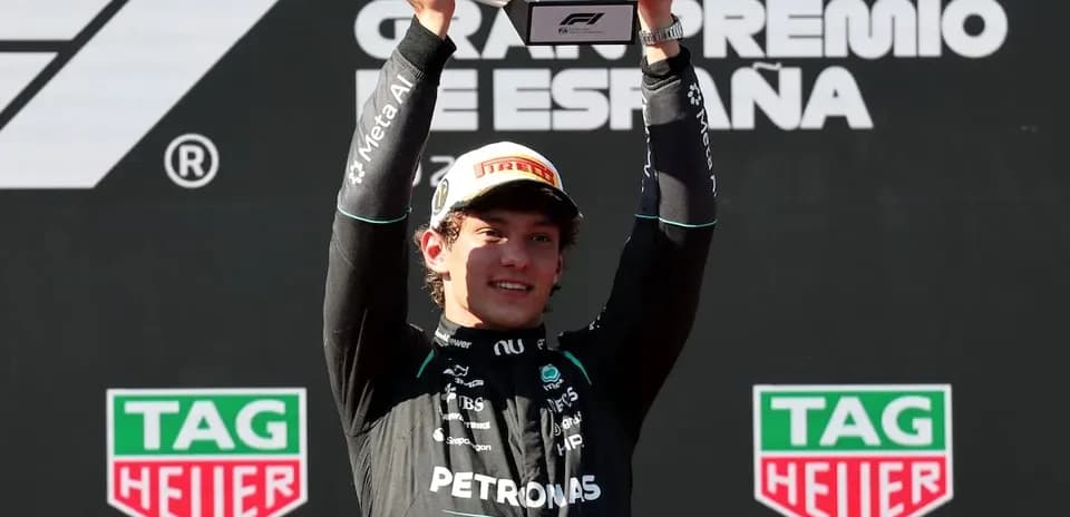 Piloto levantando trofeo en el podio del Gran Premio