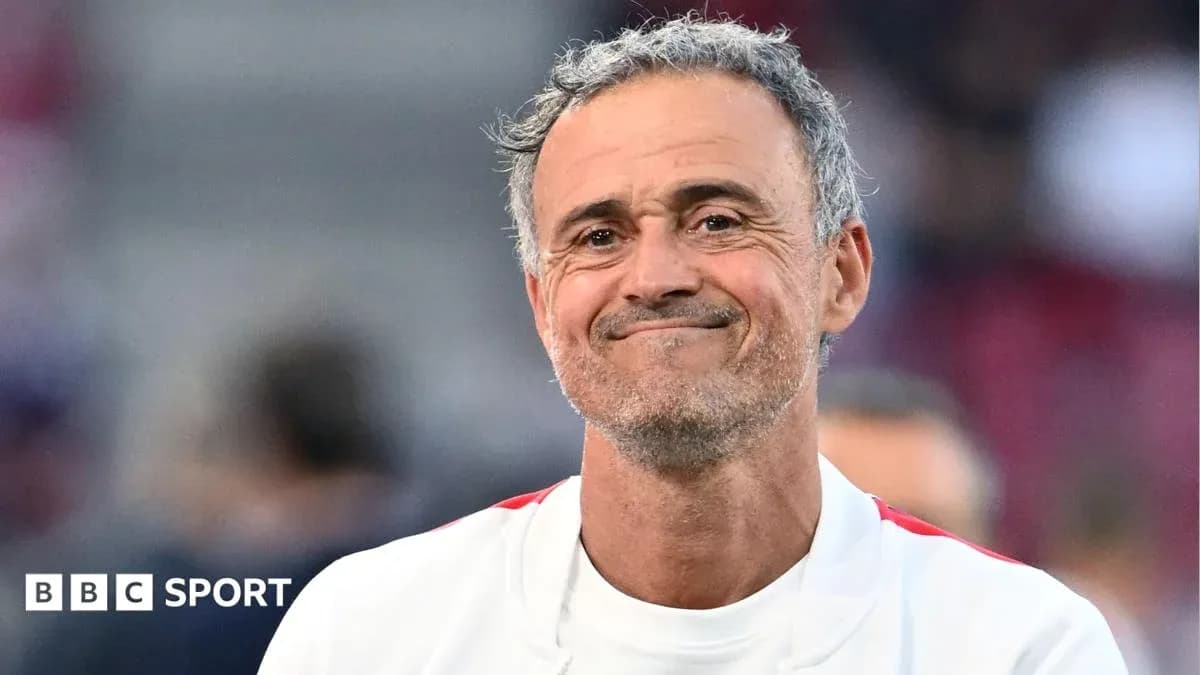 Entrenador sonriendo en el campo de fútbol