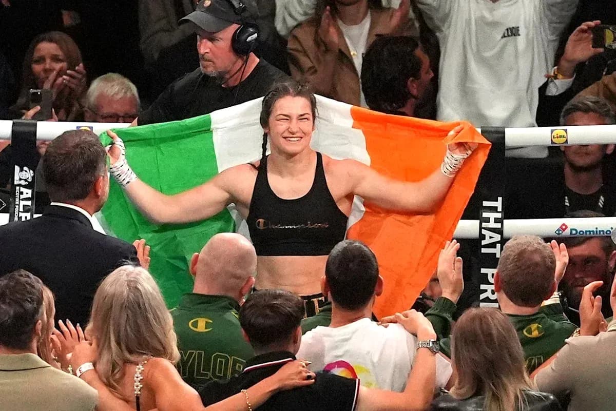 Boxeadora sosteniendo la bandera irlandesa en el ring