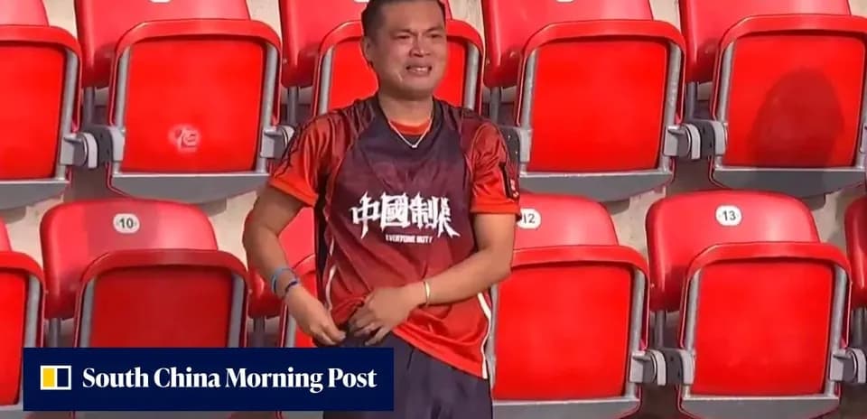 A fan in a stadium wearing an orange jersey