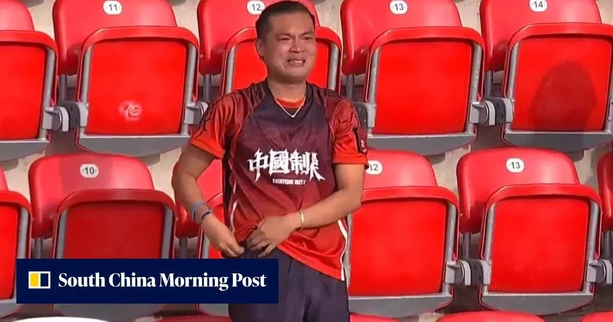 A fan in a stadium wearing an orange jersey