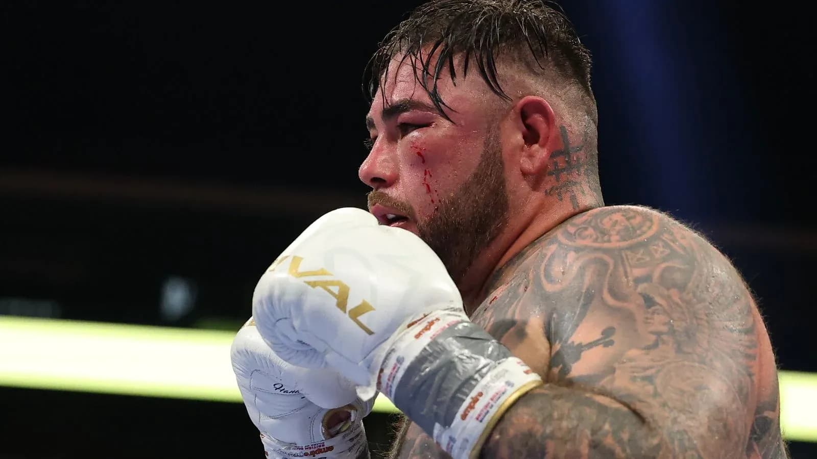 Boxeador con guantes, mostrando heridas en el rostro