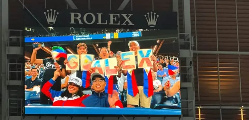 Aficionados sosteniendo carteles que dicen 'GO ALEX'