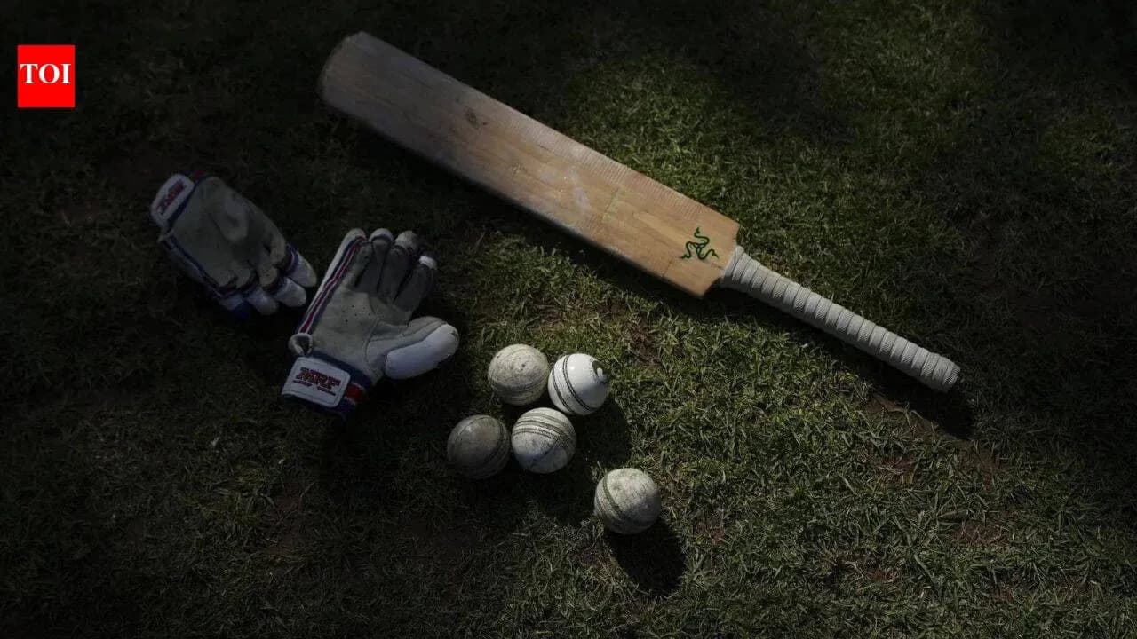 Bate de cricket y guantes sobre el césped