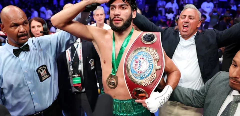 Boxeador celebrando con cinturón de campeón en ring