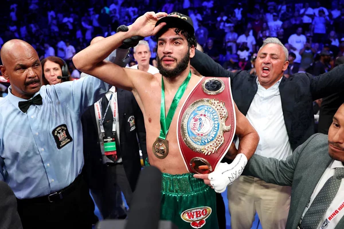 Boxeador celebrando con cinturón de campeón en ring