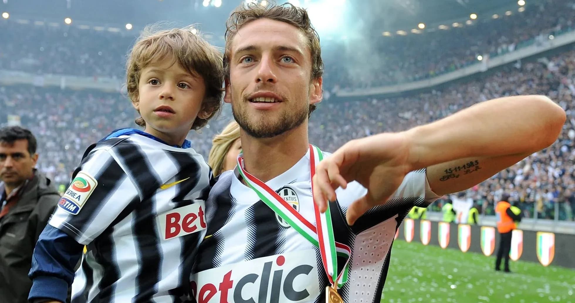 Jugador de fútbol sosteniendo a un niño en celebración