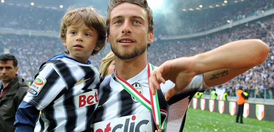 Jugador de fútbol sosteniendo a un niño en celebración