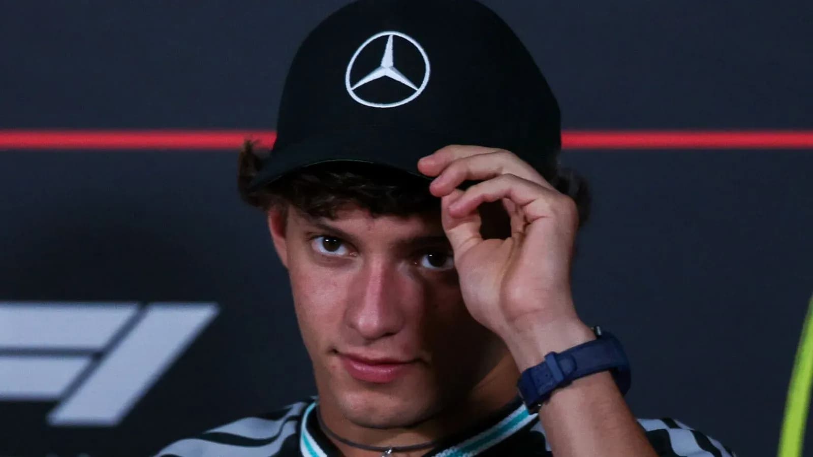 Joven con gorra de Mercedes en conferencia de prensa