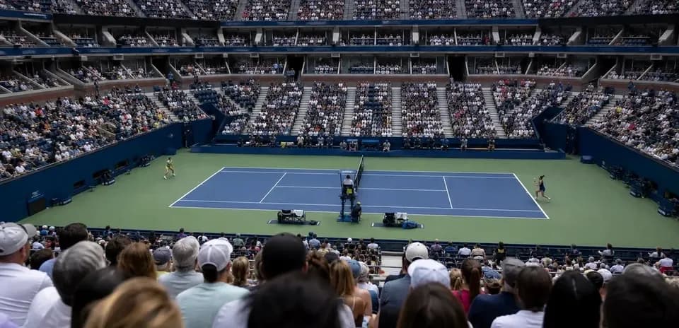 Jugadores compitiendo en una cancha de tenis llena