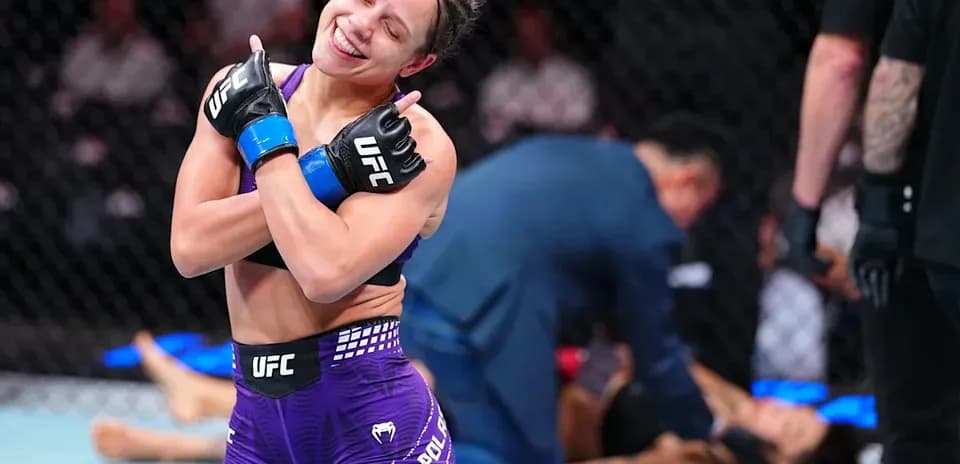 Luchadora celebrando victoria en octágono de UFC