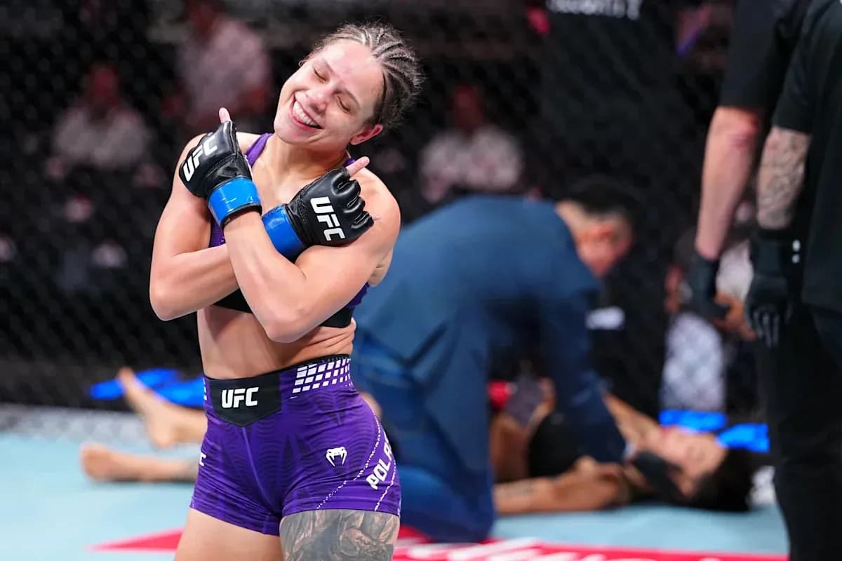 Luchadora celebrando victoria en octágono de UFC