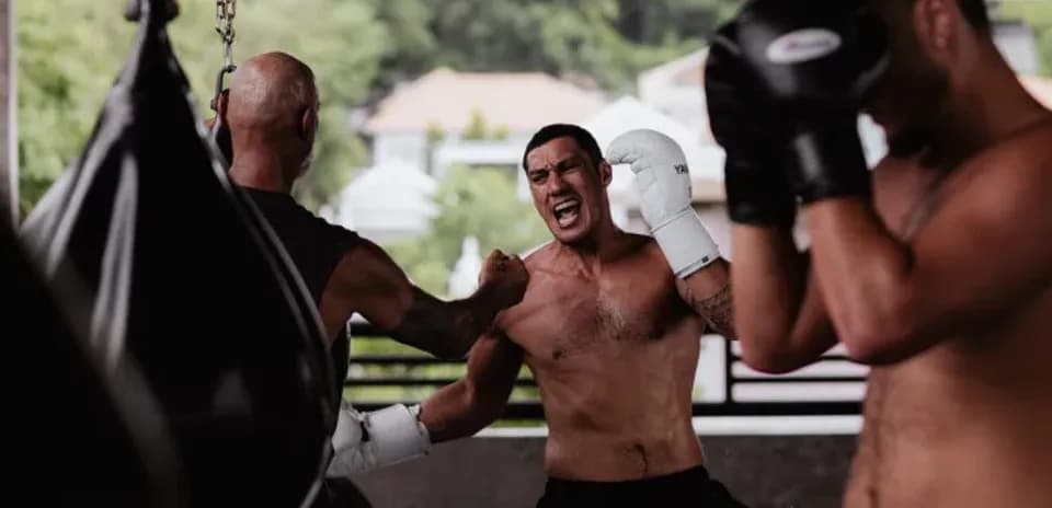 Boxeadores entrenando en gimnasio con sacos