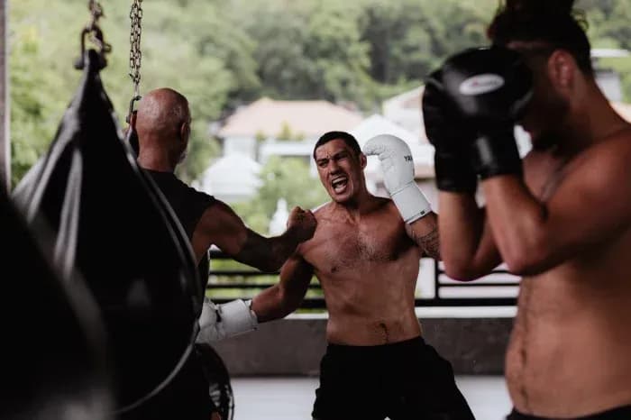 Boxeadores entrenando en gimnasio con sacos
