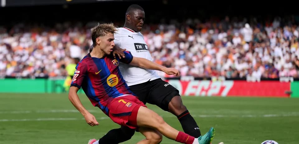 Jugador de Barcelona deslizándose tras balón en partido