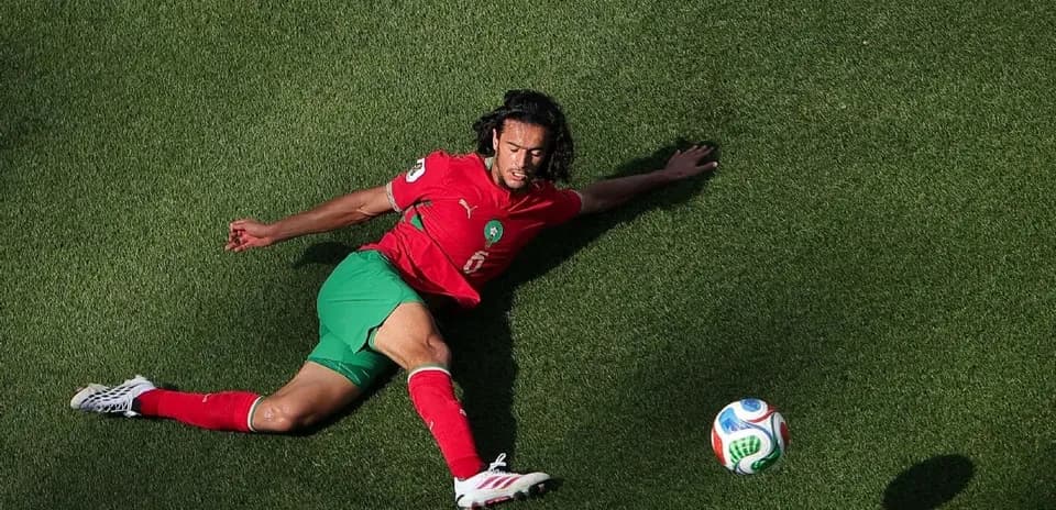 Jugador marroquí en el suelo persiguiendo el balón