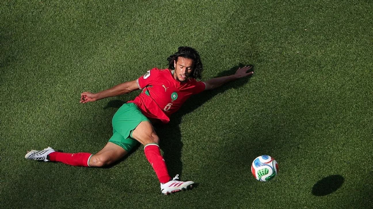 Jugador marroquí en el suelo persiguiendo el balón