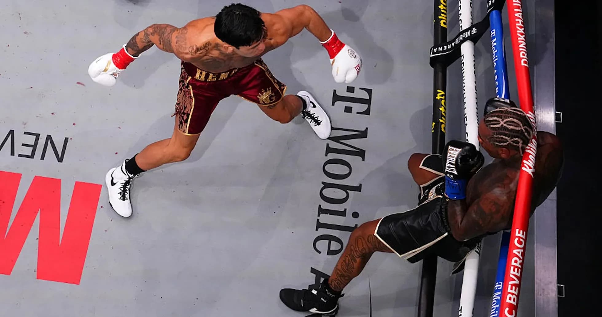 Boxer delivering a punch to opponent on canvas