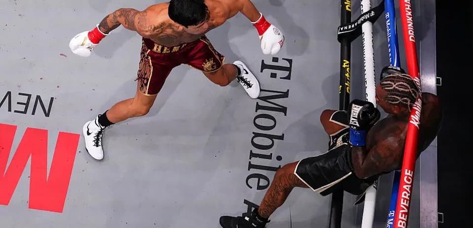 Boxer delivering a punch to opponent on canvas
