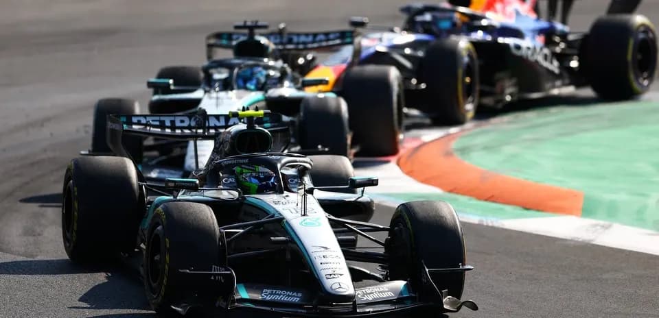 Tres coches de Fórmula 1 en una curva de carrera