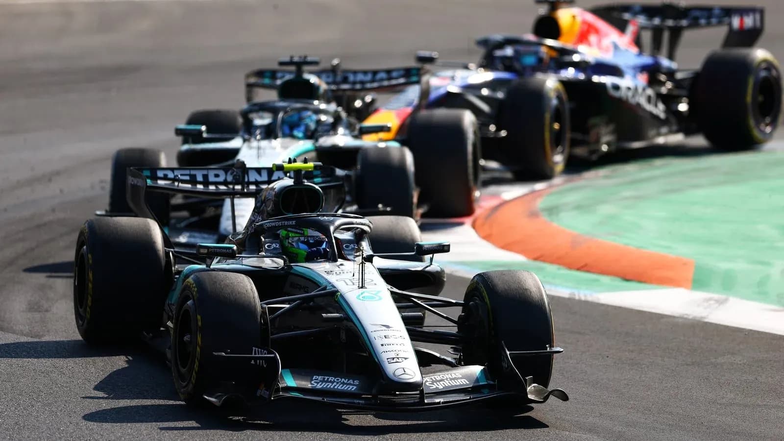 Tres coches de Fórmula 1 en una curva de carrera