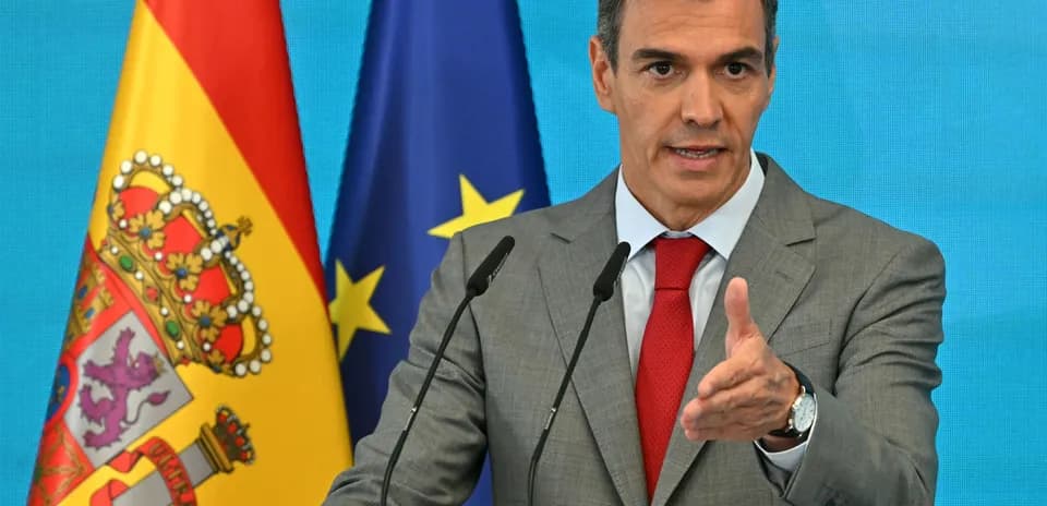 Hombre hablando en conferencia con banderas de España y UE