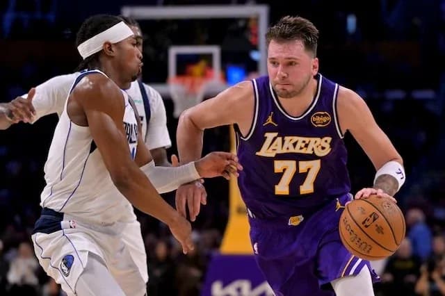 Jugador de Lakers driblando el balón frente a oponente