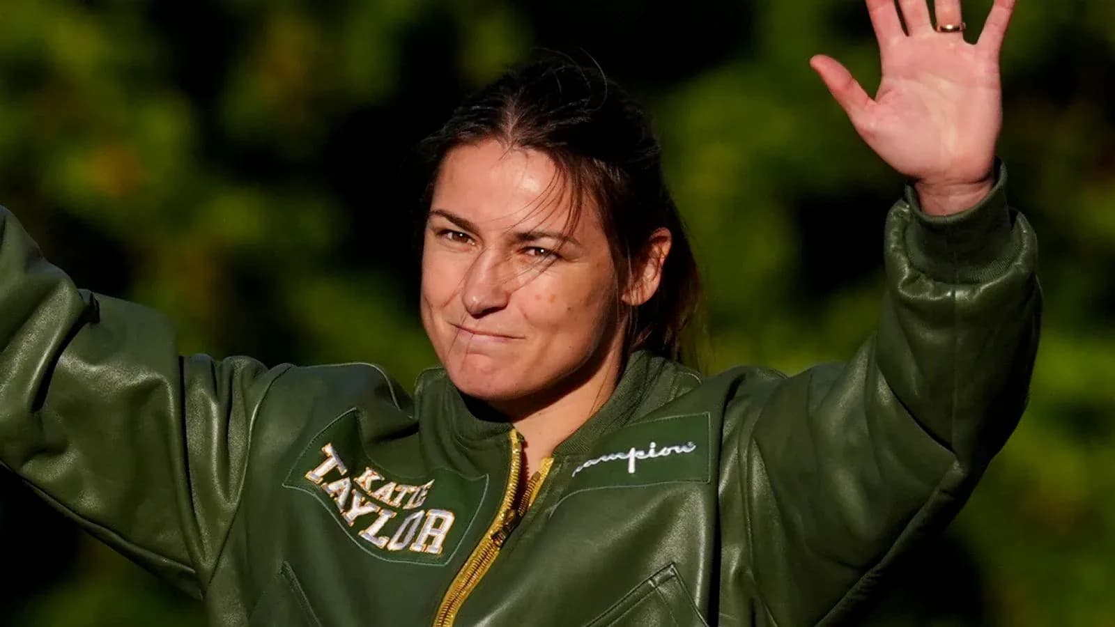 Deportista saludando con chaqueta verde