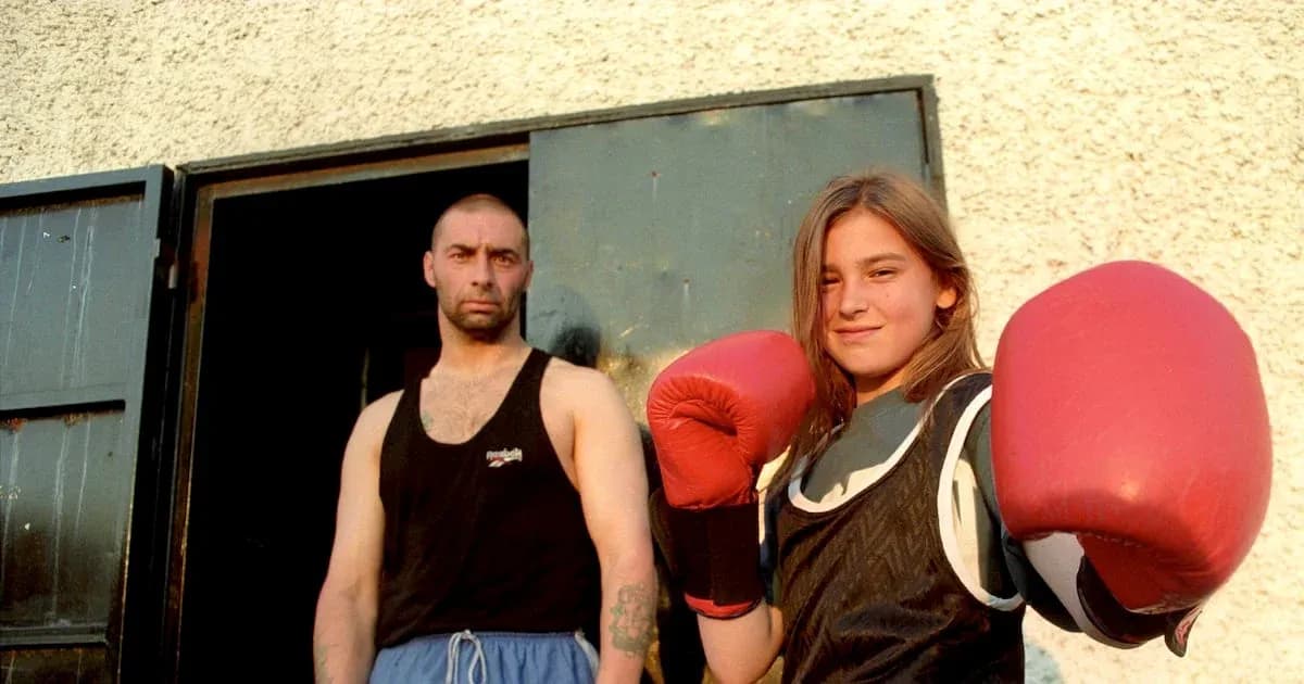 Niña boxeadora con guantes junto a un hombre