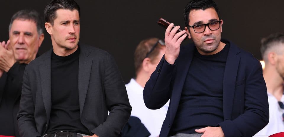Dos hombres sentados en un palco durante un evento