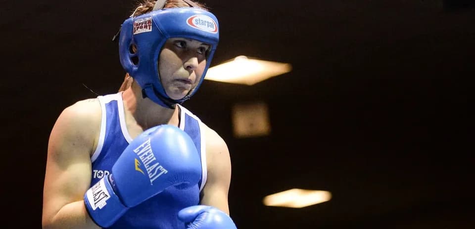 Boxeadora con guantes azules en el ring