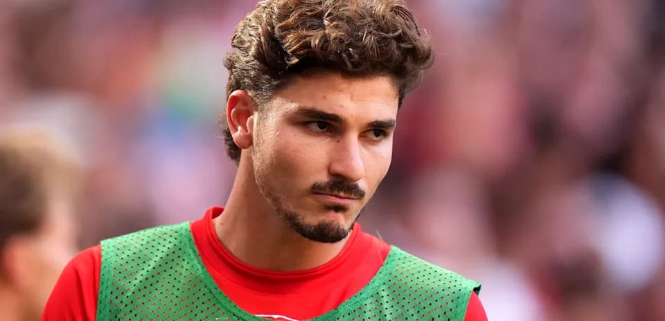 Jugador en el banquillo con camiseta de calentamiento