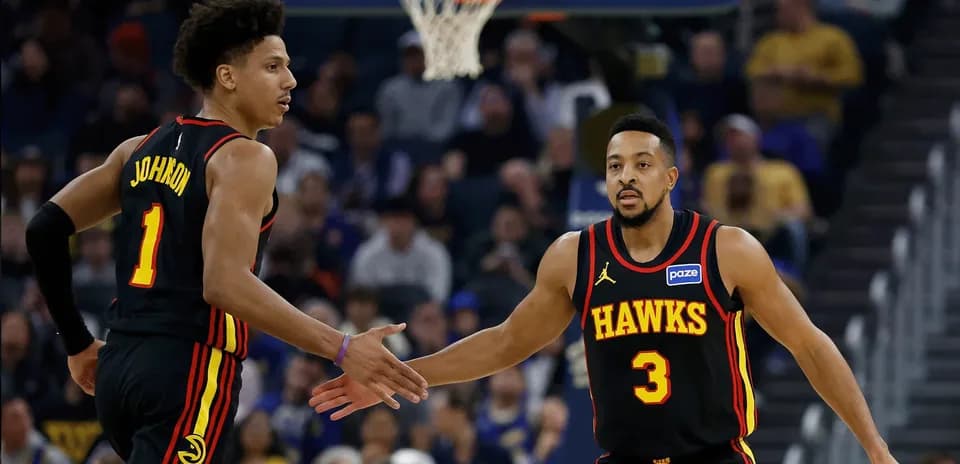 Jugadores de los Hawks chocando las manos en partido