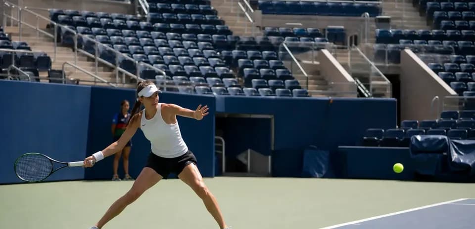 Jugadora de tenis golpeando la pelota en la cancha