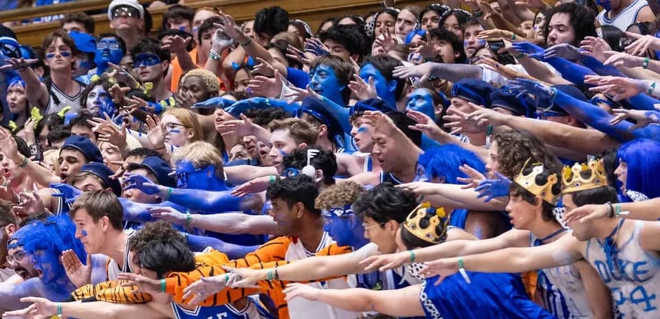 Aficionados de Duke animando con cara y brazos pintados