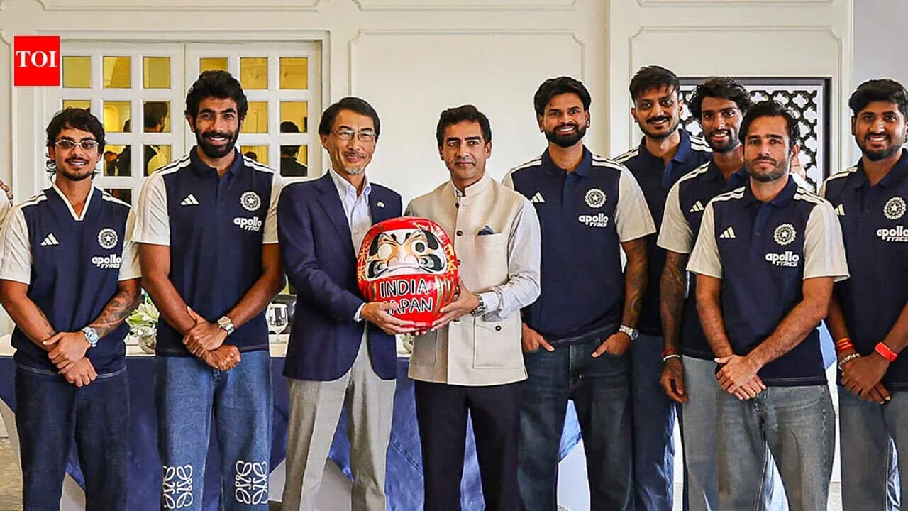 Jugadores de cricket posando con un daruma