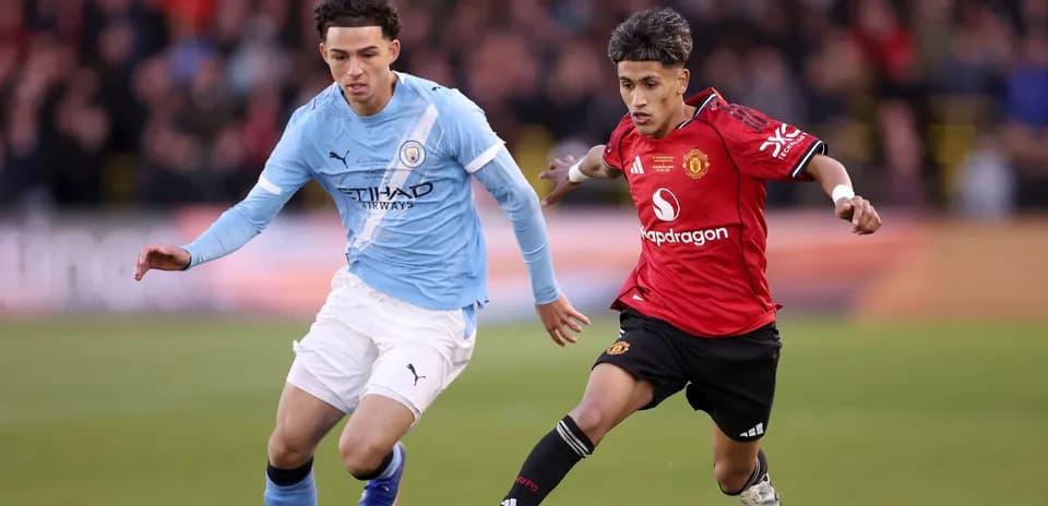 Jugadores de Manchester City y Manchester United corriendo tras el balón