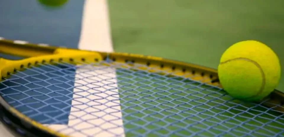 Pelota de tenis sobre una raqueta amarilla