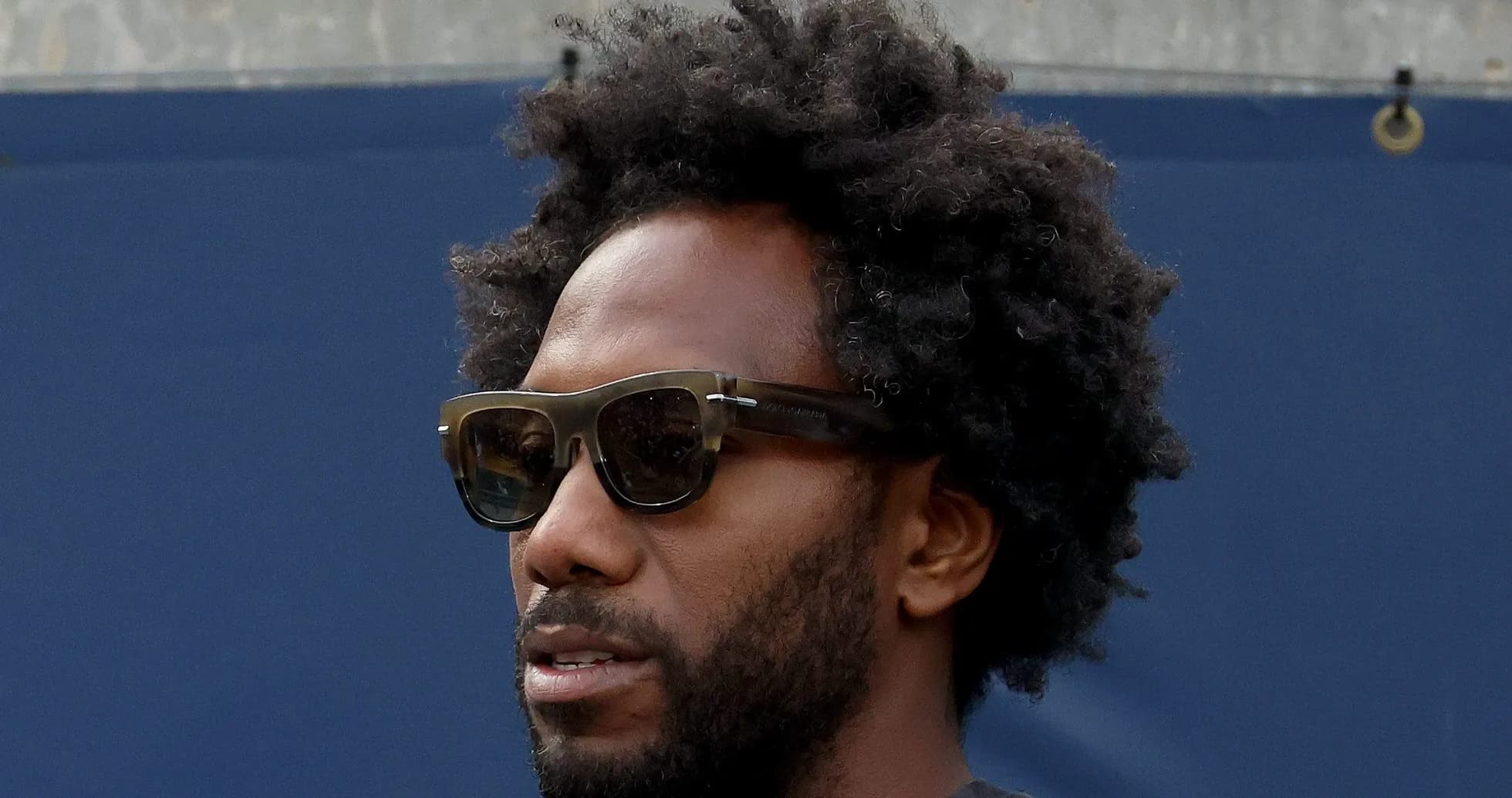 Hombre con gafas de sol y cabello rizado