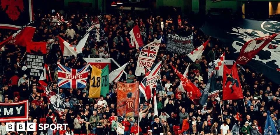 Aficionados con banderas animando en un estadio