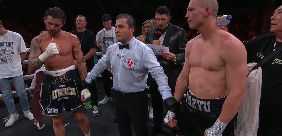 Boxeadores y árbitro en el ring tras combate