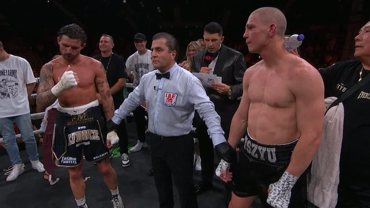 Boxeadores y árbitro en el ring tras combate
