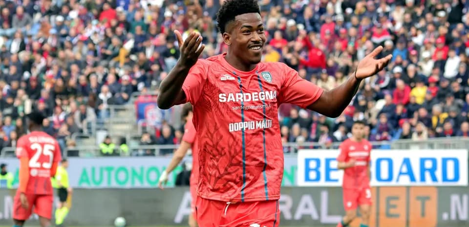 Jugador celebrando en partido de fútbol con aficionados