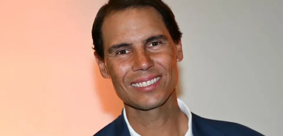Hombre sonriendo con traje en fondo claro