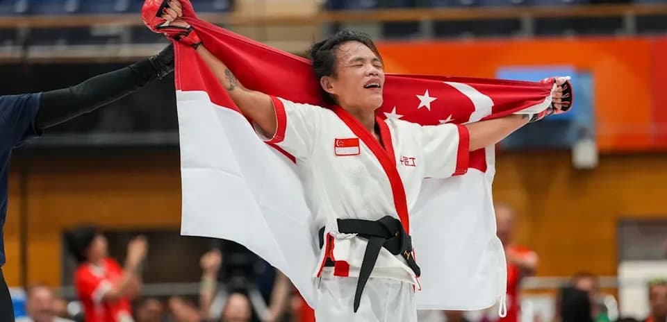 Competidor sosteniendo la bandera de Singapur en celebración