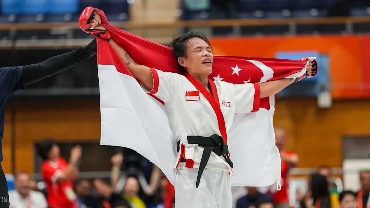 Competidor sosteniendo la bandera de Singapur en celebración