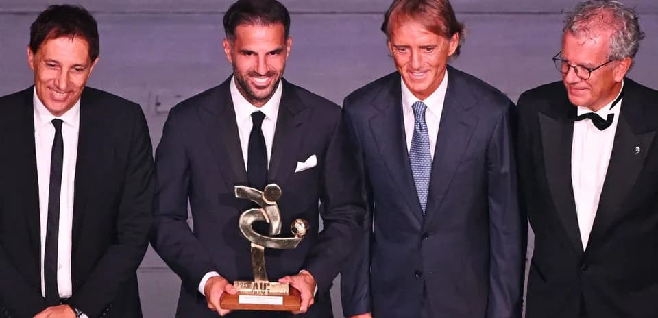 Cuatro personas posando con un trofeo en evento